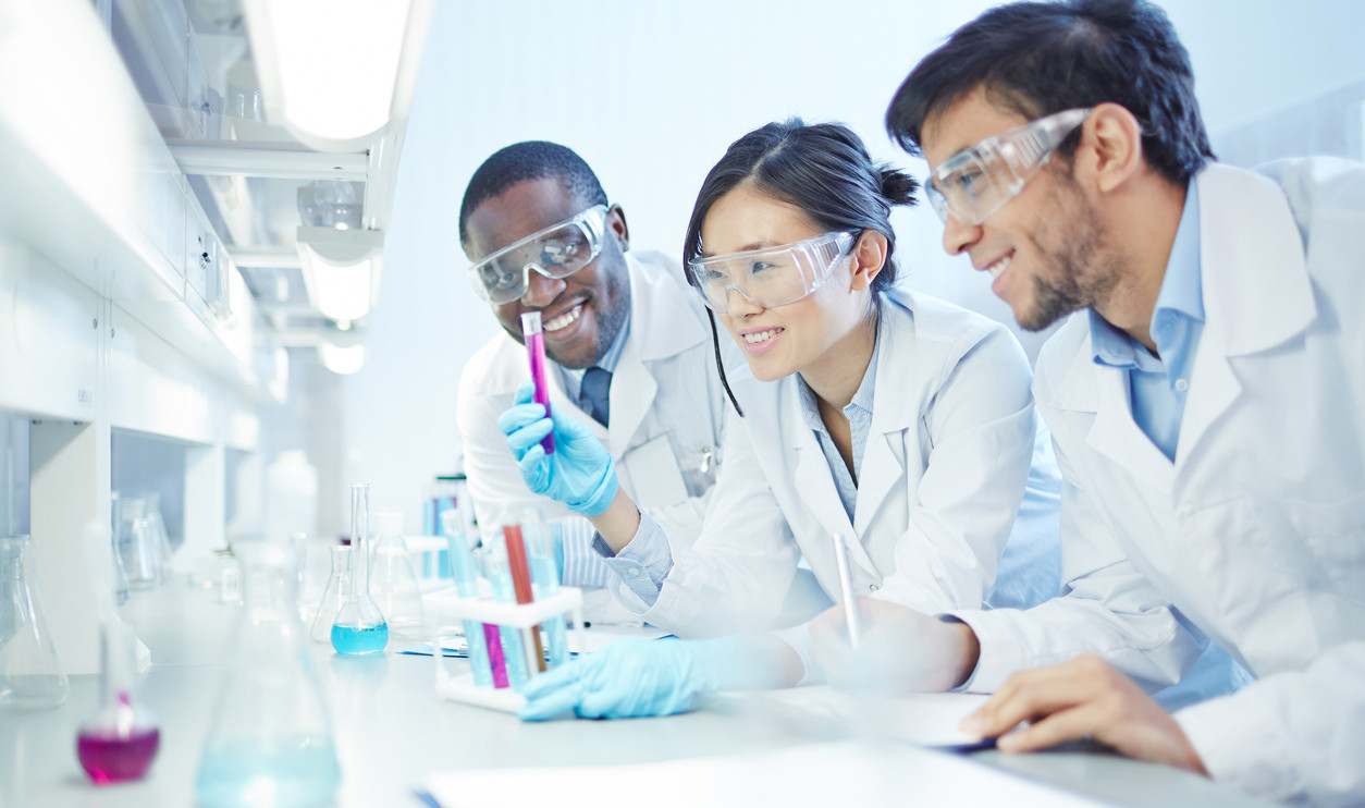 Scientists looking at flask analyzing results.